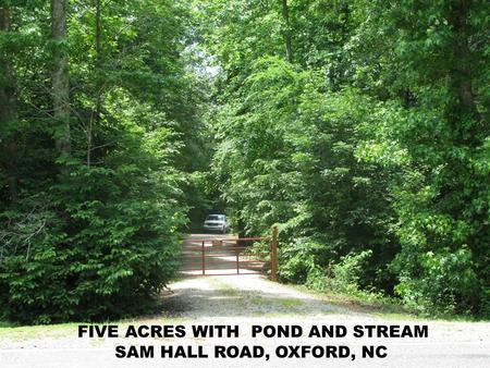 WOODED PROPERTY BOUNDARY ALONG SAM HALL ROAD SECURITY GATE AT PROPERTY ENTRANCE.