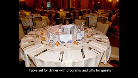 Table set for dinner with programs and gifts for guests