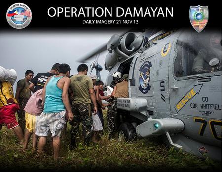 Naval Aircrewman Tactical 2nd Class Chris Miller, left, assigned to the Warlords of Helicopter Maritime Strike Squadron (HSM) 51, greets villagers during.