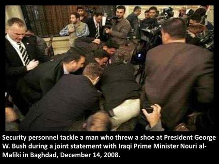 Security personnel tackle a man who threw a shoe at President George W. Bush during a joint statement with Iraqi Prime Minister Nouri al- Maliki in Baghdad,