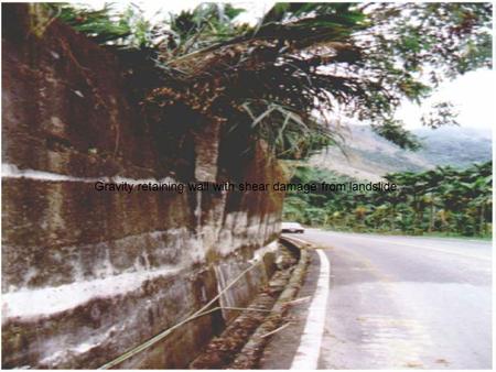 Gravity retaining wall with shear damage from landslide.