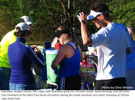 Volunteer Shelley Flones, left, helps refill hydration packs for 50-mile runner Sarah Henning and 100-miler Carl Cleveland at the West Park Road aid station.